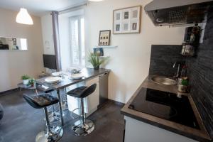 una cocina con barra y un bar con taburetes en Cosy Saint Malo Beach en Saint-Malo