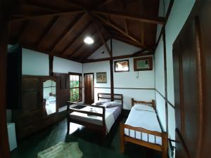 a bedroom with two beds in a room at Casa Pomar do Aconchego in Paraty