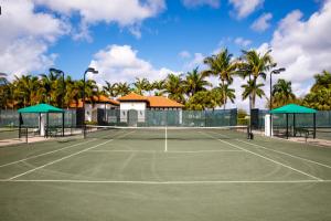 a tennis court with palm trees in the background at Naples Bay Resort and Marina in Naples