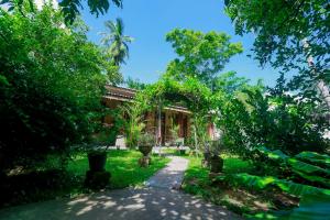a garden with trees and a building at DANDELION - Unawatuna in Unawatuna
