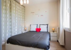 a bedroom with a bed with a red heart pillow at SWEETHOME DIJON - Gare in Dijon