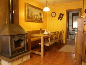 ein Esszimmer mit einem Tisch und einem Holzofen in der Unterkunft Chalet Rural El Encanto in Ojedo