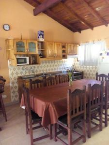 eine Küche mit einem Tisch und Stühlen sowie eine Küche mit in der Unterkunft casa emilia in Villa Gesell