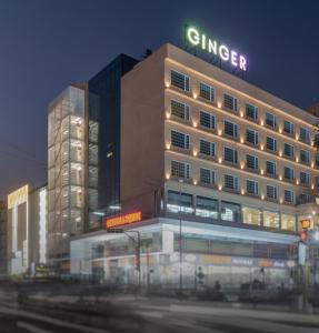 un edificio iluminado con un cartel encima en Ginger Surat City Centre en Surat