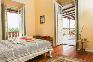 a bedroom with a bed and a balcony at The Colonial Guest House in São Filipe