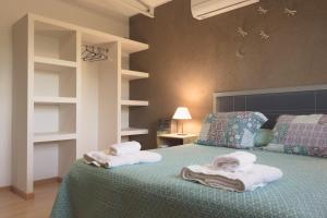1 dormitorio con 1 cama con toallas en Apart Hotel La Bodega en San Rafael