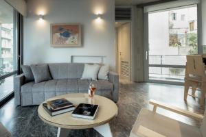 ein Wohnzimmer mit einem Sofa und einem Tisch in der Unterkunft Athens BlueBuilding in Athen