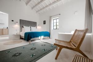 a bedroom with a bed and a tub and a chair at Santa Ponsa Fontenille Menorca in Alaior