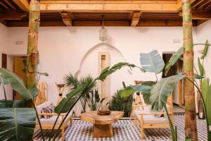 a room with plants and a table and chairs at Riad Le Pèlerin in Marrakesh