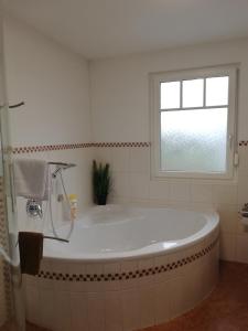 a white bath tub in a bathroom with a window at Ferienwohnung Anderl in Reischenhart