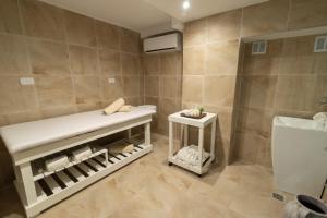 a bathroom with a bench next to a toilet at Ker San Telmo Hotel in Buenos Aires +55 photos