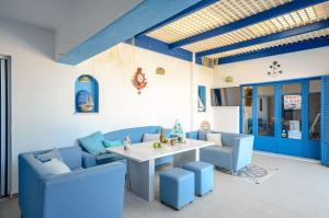 a dining room with blue chairs and a table at Agyra Studios in Agios Prokopios
