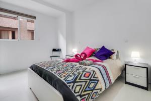 a white bedroom with a large bed and a window at Santa Cruz centro wifi tranvía 10 in Santa Cruz de Tenerife
