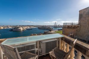 a balcony with chairs and a view of the water at Harbour Heights in Valletta