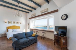 a bedroom with a couch and a bed and a tv at Harbour Heights in Valletta
