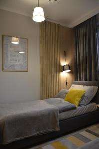 1 dormitorio con 1 cama con almohada amarilla en "11" SŁOŃCE WODA LAS - Apartament No11 Garaż w cenie, en Kielce