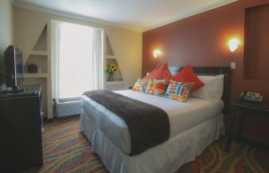 a hotel room with a large bed with colorful pillows at Nesva Hotel - New York City Vista in Queens