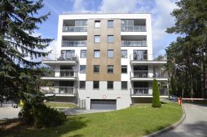 un edificio de apartamentos con aparcamiento y árboles en "11" SŁOŃCE WODA LAS - Apartament No11 Garaż w cenie, en Kielce