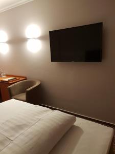 a hotel room with a bed and a flat screen tv at Hotel Victoria in Bad Kreuznach