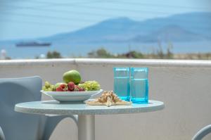 a table with a bowl of fruit and a glass of water at Agyra Studios in Agios Prokopios