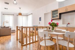 Il comprend une cuisine et un salon avec une table et des chaises. dans l'établissement Villa Porto- Naftilos Residences, à Pythagoreio