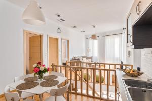 cocina y sala de estar con mesa y sillas en Villa Porto- Naftilos Residences en Pythagóreion