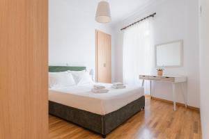 1 dormitorio con cama y escritorio. en Villa Porto- Naftilos Residences en Pythagóreion