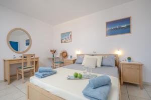 a bedroom with a bed and a table with fruit on it at Agyra Studios in Agios Prokopios