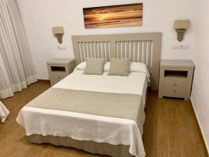 
a hotel room with a bed and a dresser at Hotel Almadrabeta in Zahara de los Atunes
