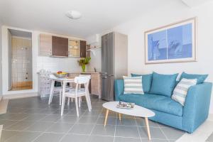 a living room with a blue couch and a table at Naftilos Residences I in Potokáki