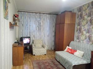 a living room with a couch and a chair and a tv at Апартаменты в центре (Красная площадь) in Chernihiv