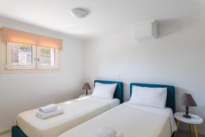 two beds sitting next to each other in a room at Naftilos Residences I in Potokáki