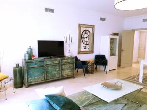 sala de estar con TV y sofá en Garden Apartment in Finca Cortesin, Altos de Cortesin, en Casares