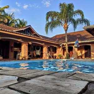 a swimming pool in front of a house at Pousada Na Praia Ubatuba in Ubatuba