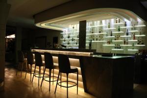 a bar with a row of stools in a room at Hotel International Prishtina & Spa in Pristina