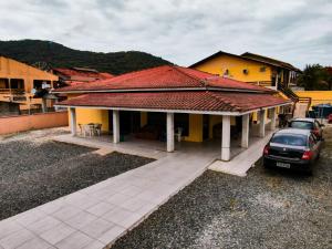 a house with a car parked in front of it at Pousada Parque Praia in Penha