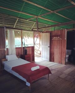 a bedroom with a bed and a green ceiling at Casa Kukama Lodge in Iquitos