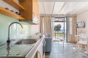 a kitchen with a sink and a counter with a table at Naftilos Residences I in Potokáki