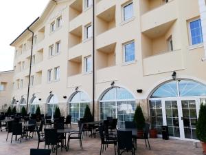 Una fila de mesas y sillas afuera de un edificio en Villa Della Rosa, en Razgrad