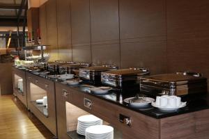 a buffet line in a restaurant with white plates at Hotel International Prishtina & Spa in Pristina