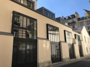 a building with black doors and windows on a street at Hôtel Villa Blomet in Paris