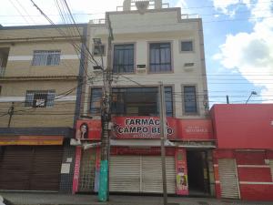a building with a sign on the side of it at Paradise Hostel e Suítes in Itatiaia
