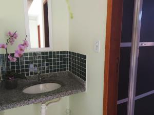 a bathroom with a sink and a mirror at Paradise Hostel e Suítes in Itatiaia +33 photos