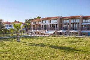 a building with a palm tree in front of it at Naftilos Residences I in Potokáki