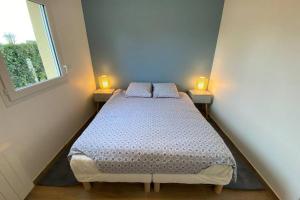 Bett in einem Zimmer mit 2 Lampen an 2 Tischen in der Unterkunft Maison 50M de la mer in Lion-sur-Mer