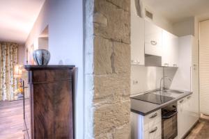 a kitchen with a stone wall and a refrigerator at Right House di Via Sulis - Best Neighborhood in the Town in Cagliari +12 photos