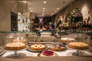 a display case with cakes and pastries on display at Right House di Via Sulis - Best Neighborhood in the Town in Cagliari