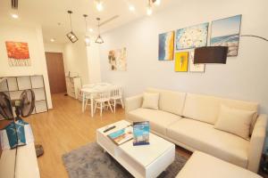 - un salon avec un canapé blanc et une table dans l'établissement Vinhomes Skylake Apartment - by Bayhomes, à Hanoï