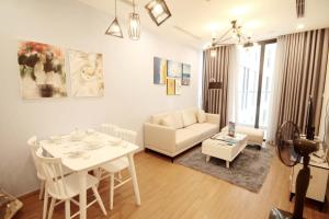 uma sala de estar com uma mesa branca e um sofá em Vinhomes Skylake Apartment - by Bayhomes em Hanói