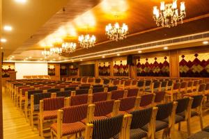 a large hall with chairs and chandeliers at Boon Inn in Malappuram